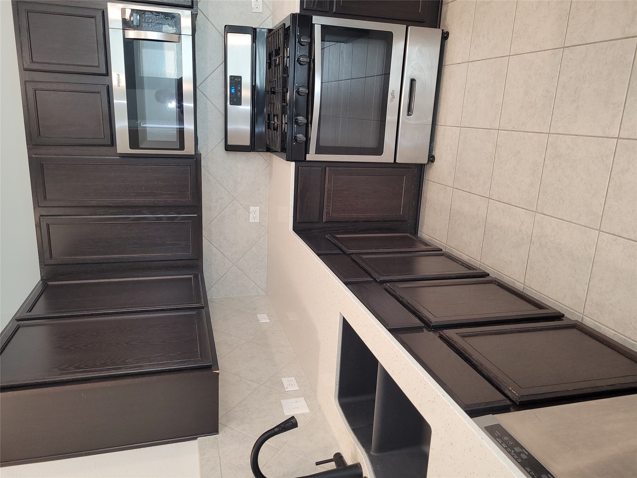 8308 Daisy Cutter Crossing Georgetown, TX 78626 - Photo 7 of 27 A well-appointed kitchen features dark wood cabinetry, light countertops, and modern stainless steel appliances.