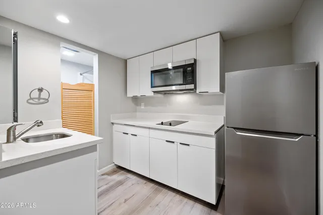 a kitchen with stainless steel appliances granite countertop a refrigerator sink and microwave