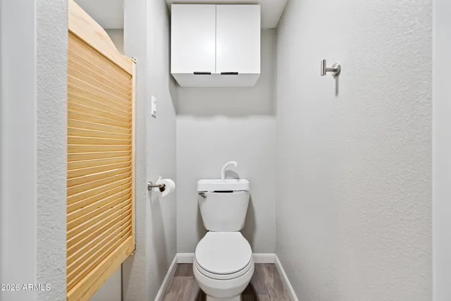a white toilet sitting in a bathroom next to a sink