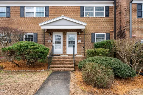 front view of a brick house with a yard