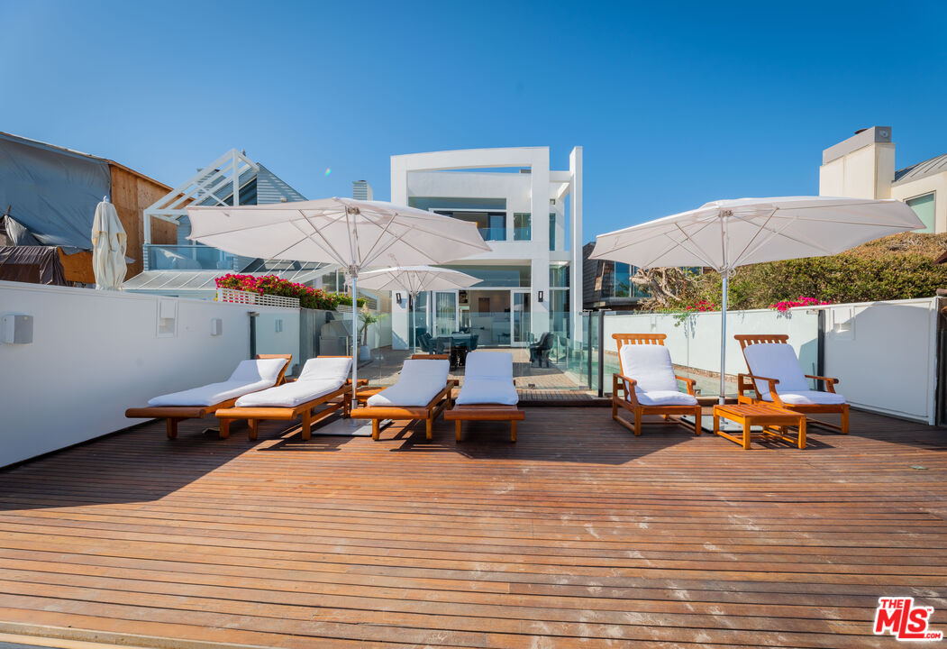 23754 Malibu Road Malibu, CA 90265 - Photo 36 of 59 a view of the patio with dining table and chairs under an umbrella