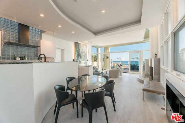 a view of a house with a small yard and large tree