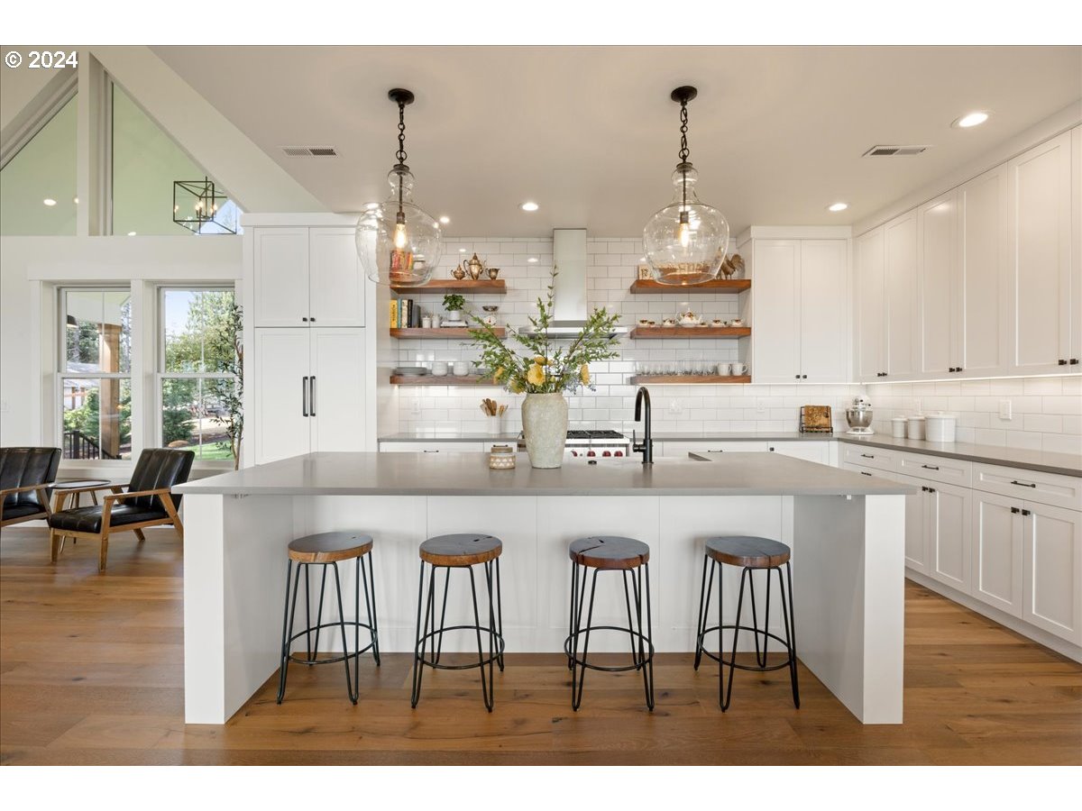 29050 Southwest Petes Mountain Road West Linn, OR 97068 - Photo 16 of 48 a kitchen with stainless steel appliances granite countertop a dining table chairs and white cabinets