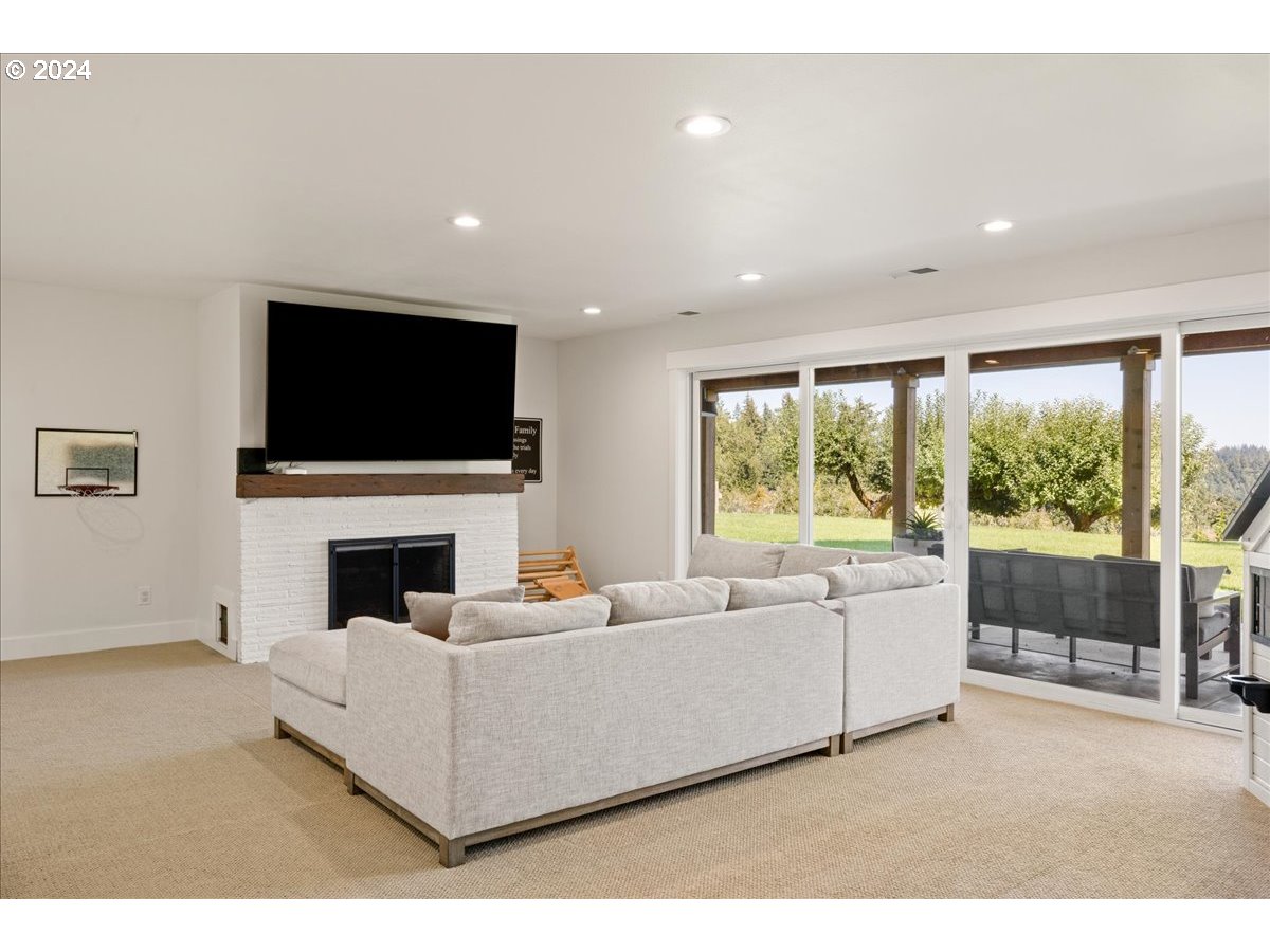 29050 Southwest Petes Mountain Road West Linn, OR 97068 - Photo 32 of 48 a living room with furniture a flat screen tv and a fireplace