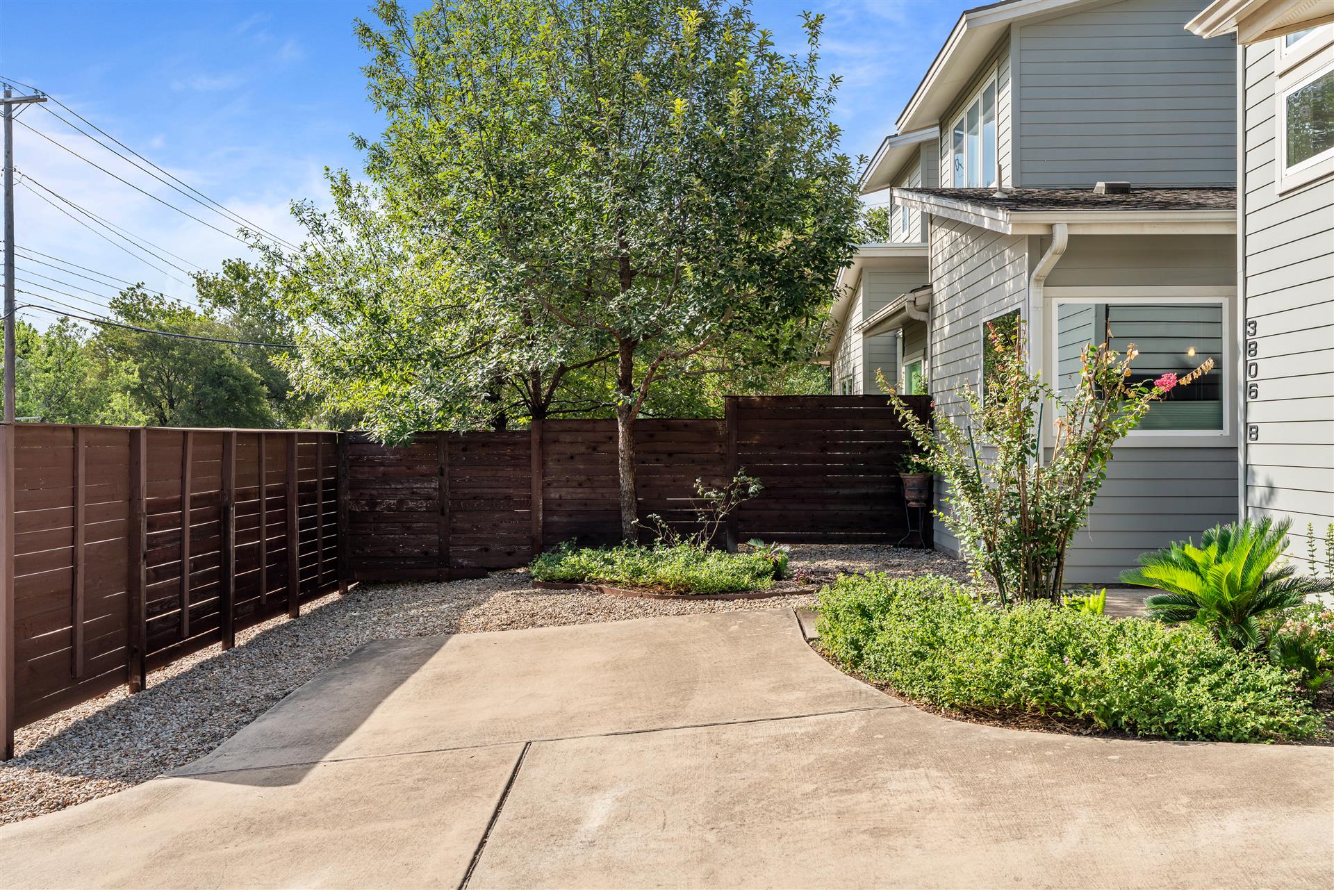 3806 Bull Creek Road, Unit B Austin, TX 78731 - Photo 35 of 37 A private, fenced courtyard creates a welcoming entrance, complemented by mature landscaping and an additional parking space.