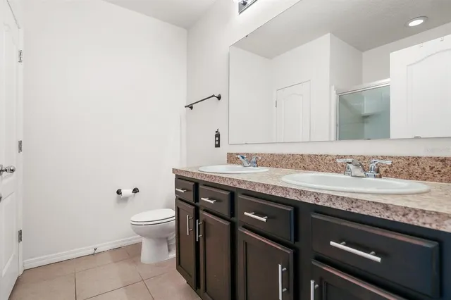a bathroom with a granite countertop sink a toilet and a mirror