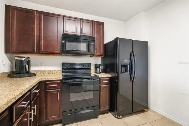 a kitchen with granite countertop wooden cabinets and stainless steel appliances