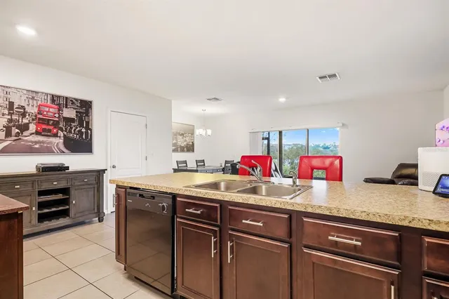 a kitchen with granite countertop a sink cabinets and stainless steel appliances
