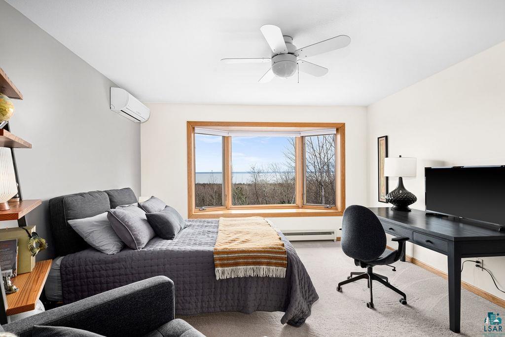 4856 Kingston Street Duluth, MN 55804 - Photo 26 of 88 Bright room featuring a large bay window with natural wood trim, providing expansive water and tree scenery