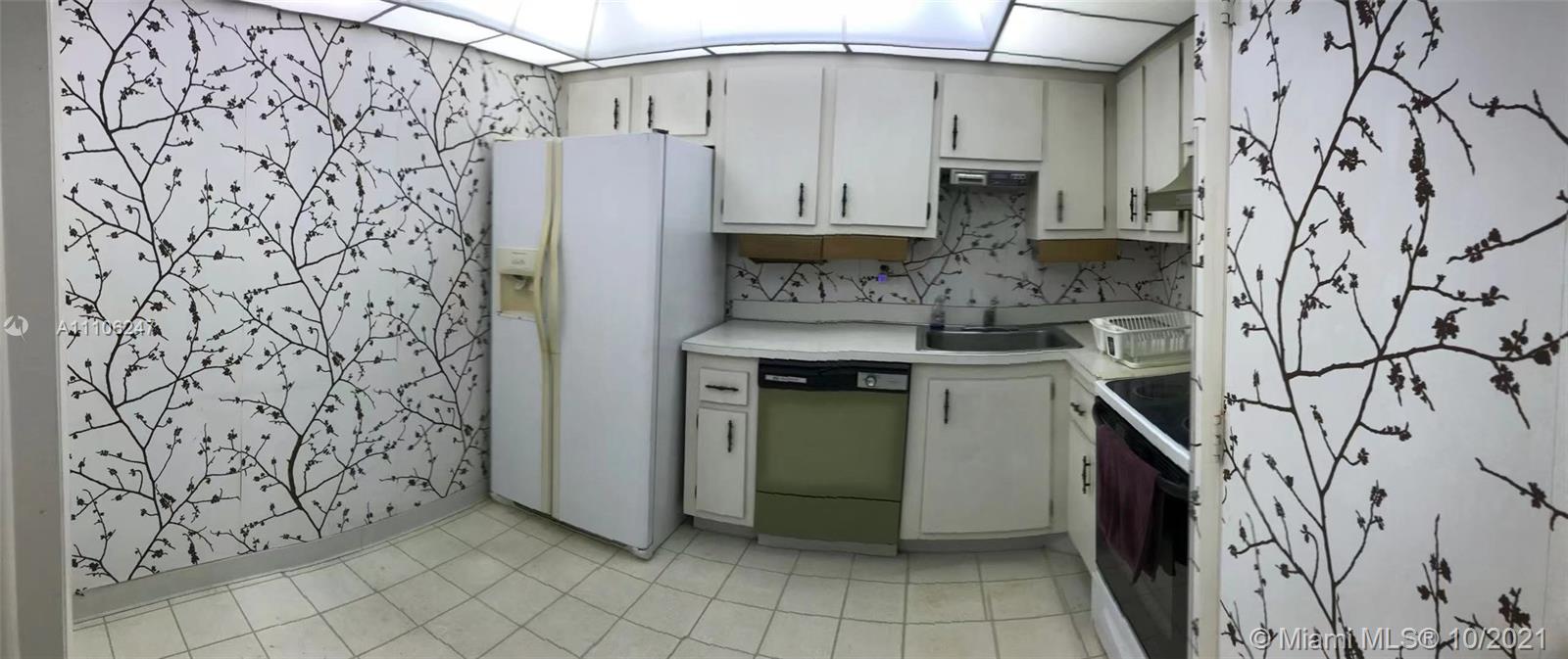 4172 Inverrary Drive, Unit 304 Lauderhill, FL 33319 - Photo 8 of 13 a kitchen with stainless steel appliances granite countertop a refrigerator and a stove