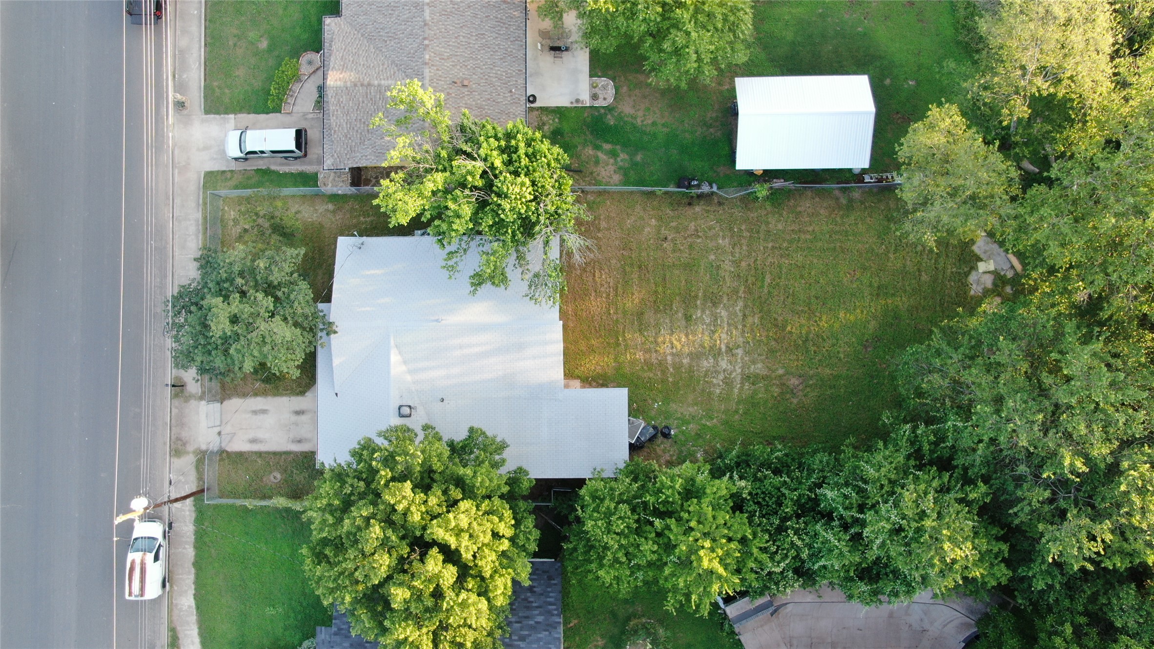 1060 Gardner Road Austin, TX 78721 - Photo 3 of 19 An aerial perspective showcases a spacious lot with an adjacent outbuilding and mature trees framing the property.