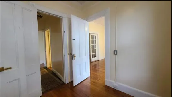 a view of a hallway with wooden floor