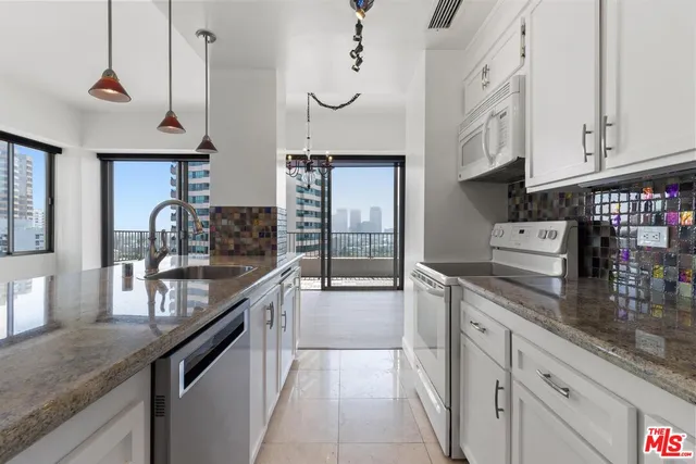 a kitchen with stainless steel appliances granite countertop a sink a stove and cabinets