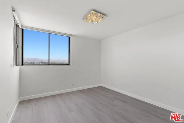 a bedroom with a bed and a lamp on dresser