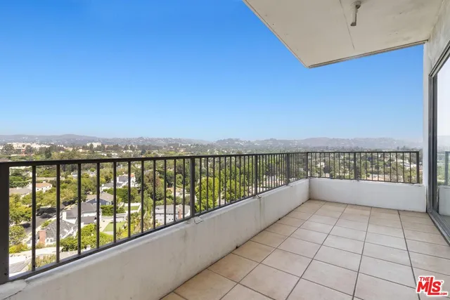 a living room with couches and kitchen view with wooden floor