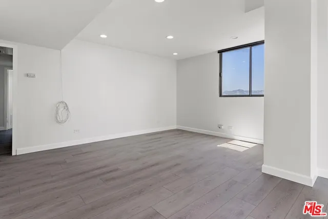 a view of a room with wooden floor and window