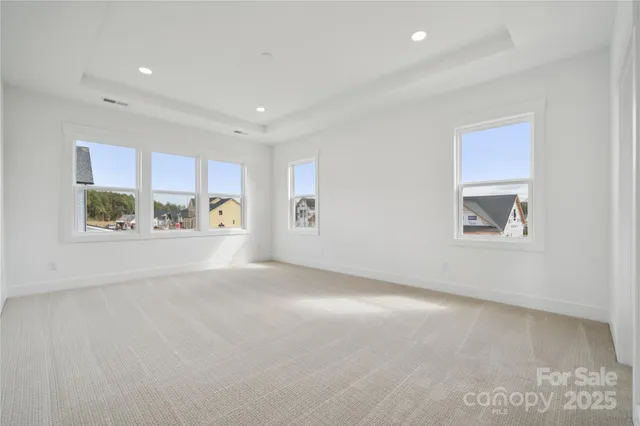 a view of an empty room with a window and a kitchen
