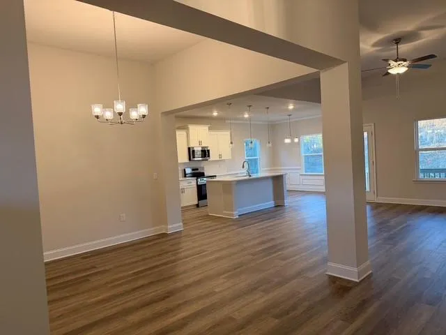 a view of an empty room with a fireplace and wooden floor