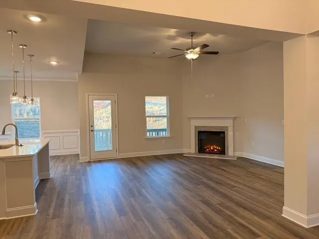 an empty room with wooden floor fireplace and windows