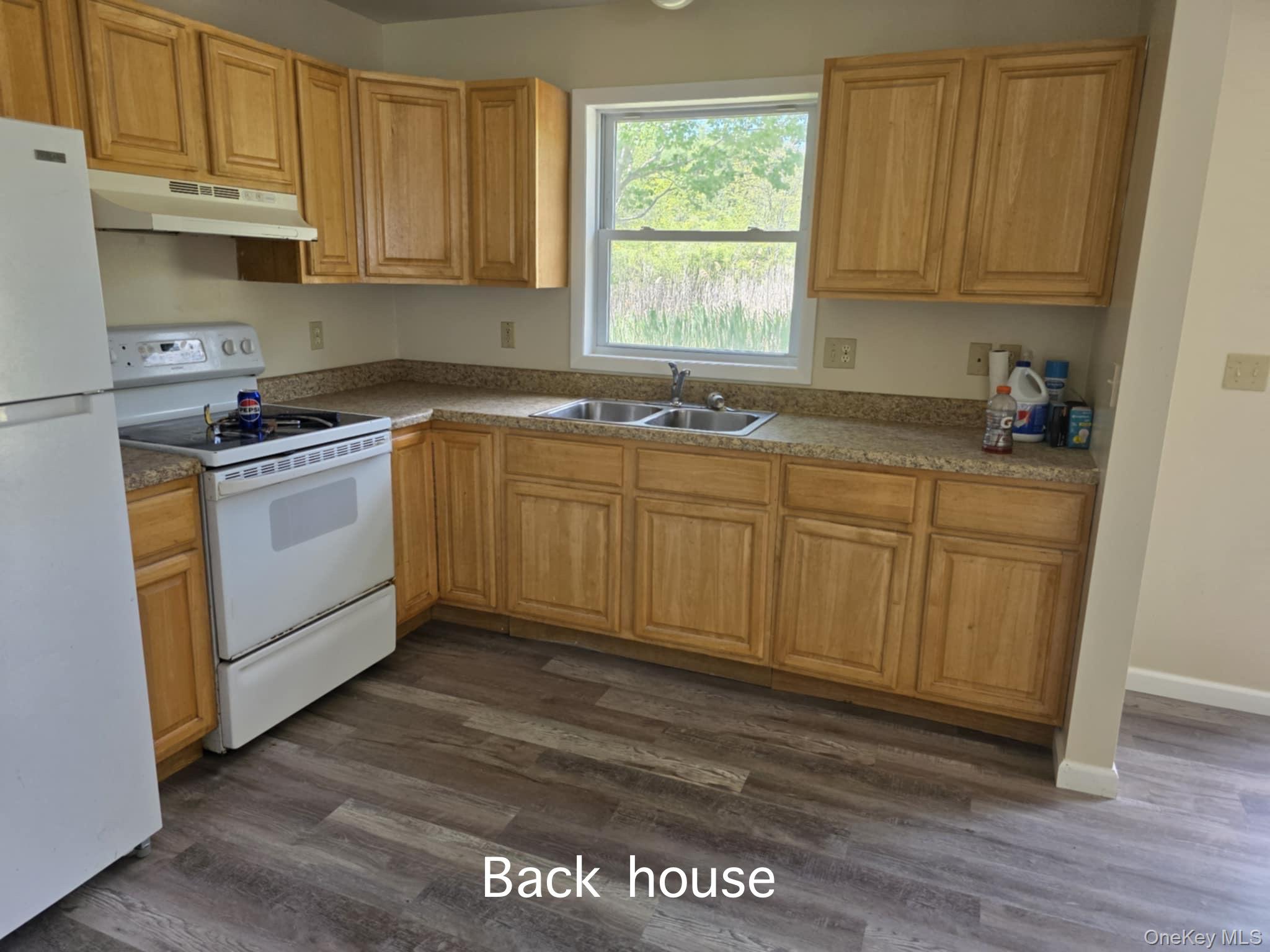 105-107 East Cold Spring Road Monticello, NY 12701 - Photo 12 of 22 Kitchen featuring white appliances, under cabinet range hood, and dark wood-style floors