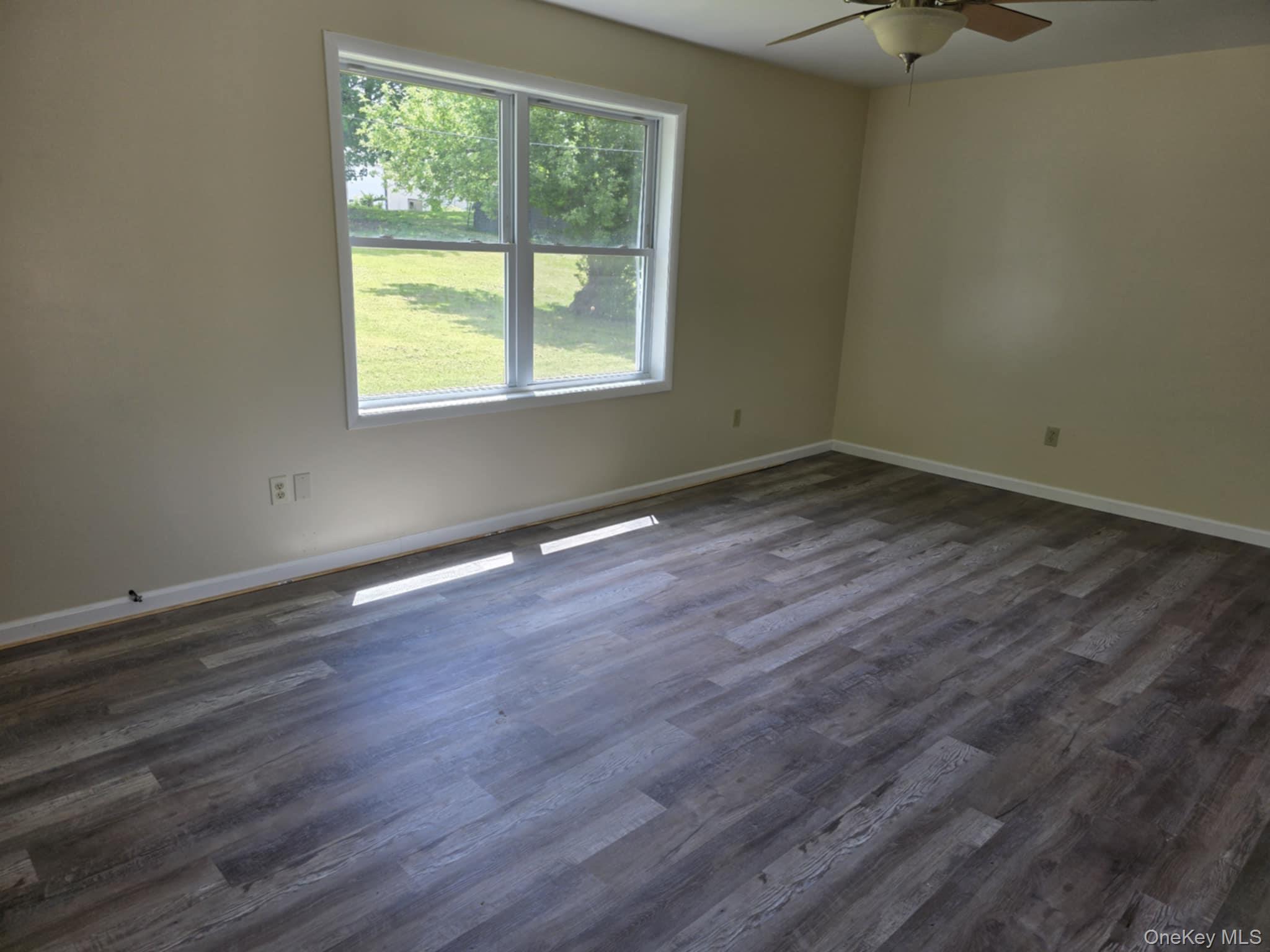 105-107 East Cold Spring Road Monticello, NY 12701 - Photo 17 of 22 Empty room with a ceiling fan and dark wood finished floors