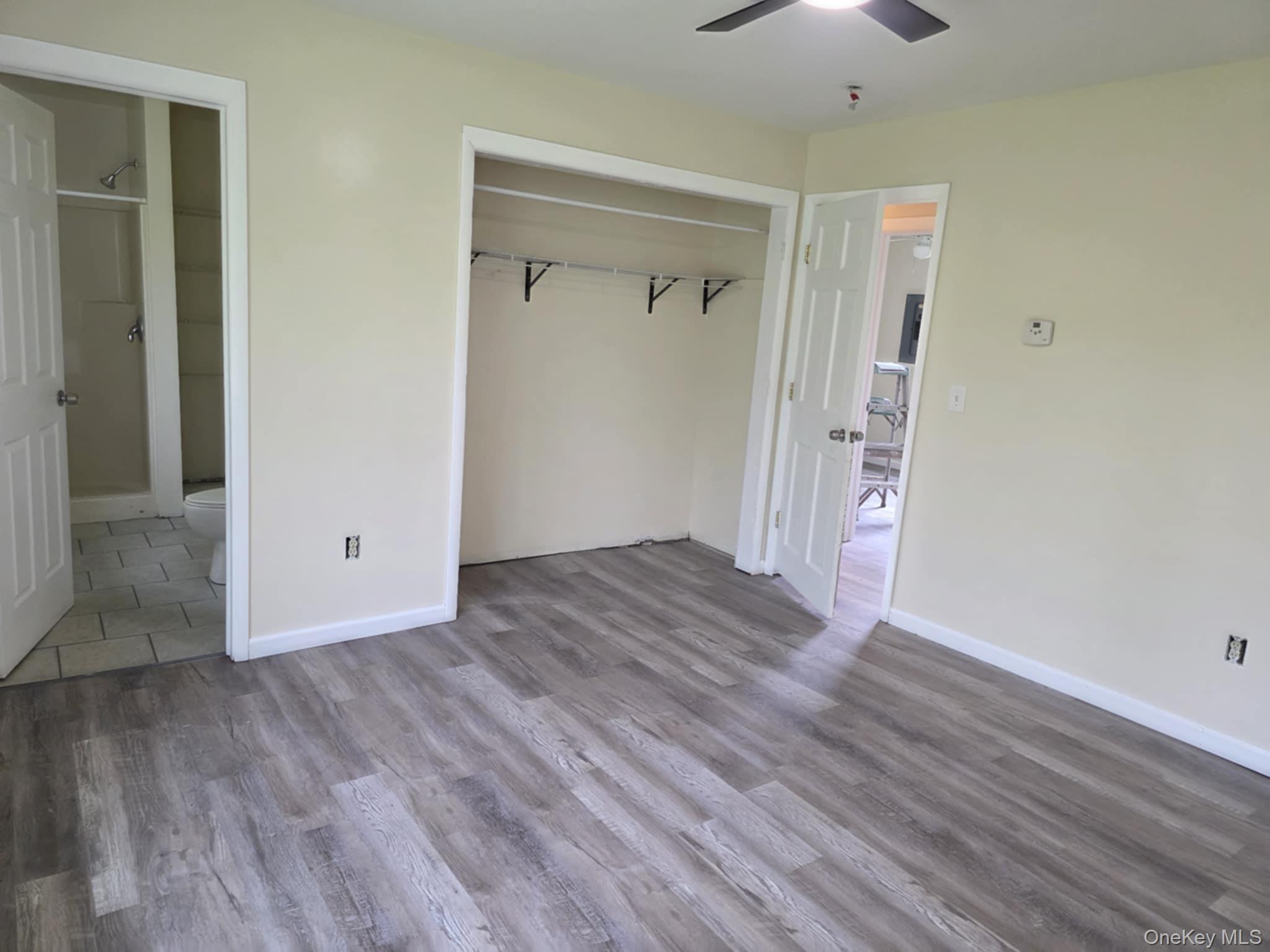 105-107 East Cold Spring Road Monticello, NY 12701 - Photo 22 of 22 Unfurnished bedroom featuring wood finished floors, a closet, and a ceiling fan
