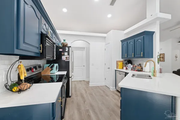 a kitchen with stainless steel appliances granite countertop a sink refrigerator and cabinets