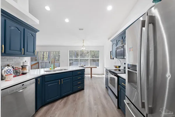 a kitchen with stainless steel appliances a sink stove and cabinets