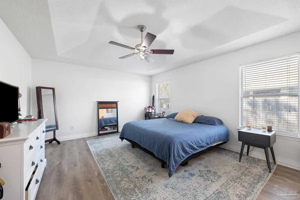 a bedroom with a bed and a flat tv screen on dresser