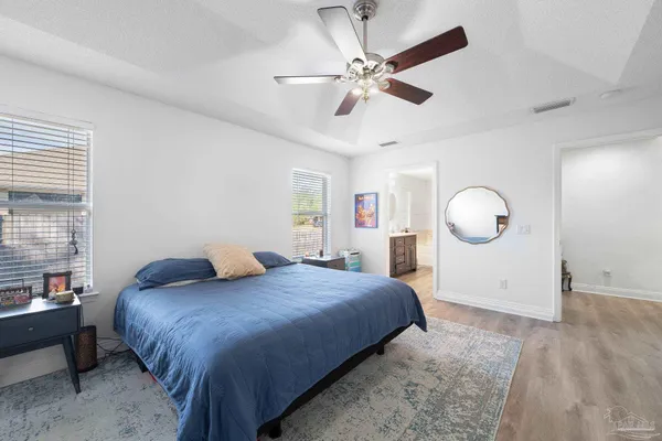 a bedroom with a large bed and a chandelier