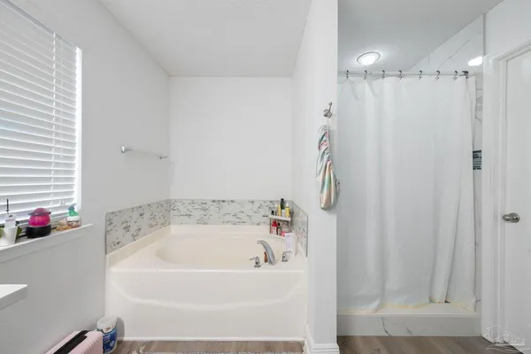 a white bath tub sitting next to a shower