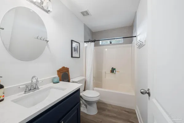 a bathroom with a granite countertop sink toilet a shower and a mirror
