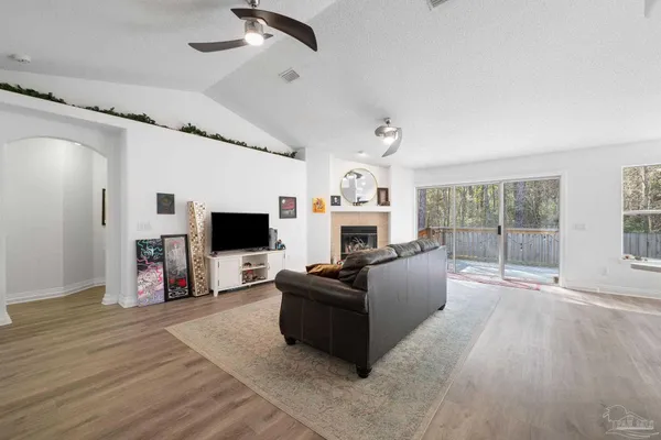 a living room with furniture a flat screen tv and a fireplace