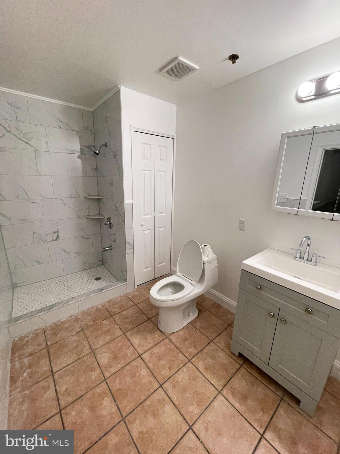 1020 Hamilton Street, Unit 4 Philadelphia, PA 19123 - Photo 12 of 19 a bathroom with a granite countertop sink a toilet and a shower
