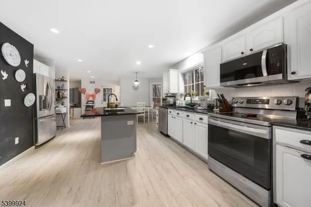 a kitchen with stainless steel appliances kitchen island granite countertop a stove a sink and a microwave