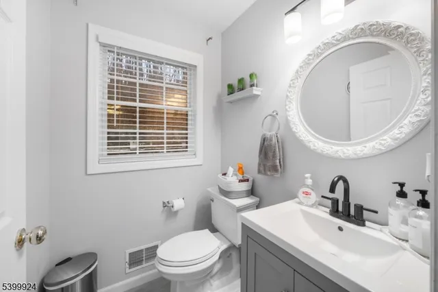 a bathroom with a toilet a sink and mirror