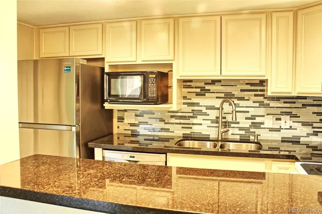 a kitchen with stainless steel appliances granite countertop a refrigerator and cabinets