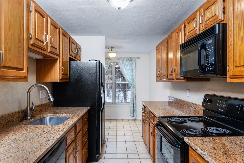 303 Ridgefield Circle, Unit B Clinton, MA 01510 - Photo 2 of 23 a kitchen with stainless steel appliances granite countertop a sink stove and refrigerator