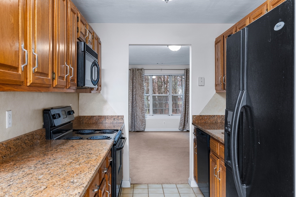 303 Ridgefield Circle, Unit B Clinton, MA 01510 - Photo 4 of 23 a kitchen with granite countertop stainless steel appliances and wooden cabinets