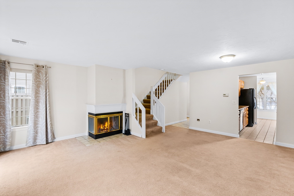 303 Ridgefield Circle, Unit B Clinton, MA 01510 - Photo 5 of 23 a view of an empty room with wooden floor and windows