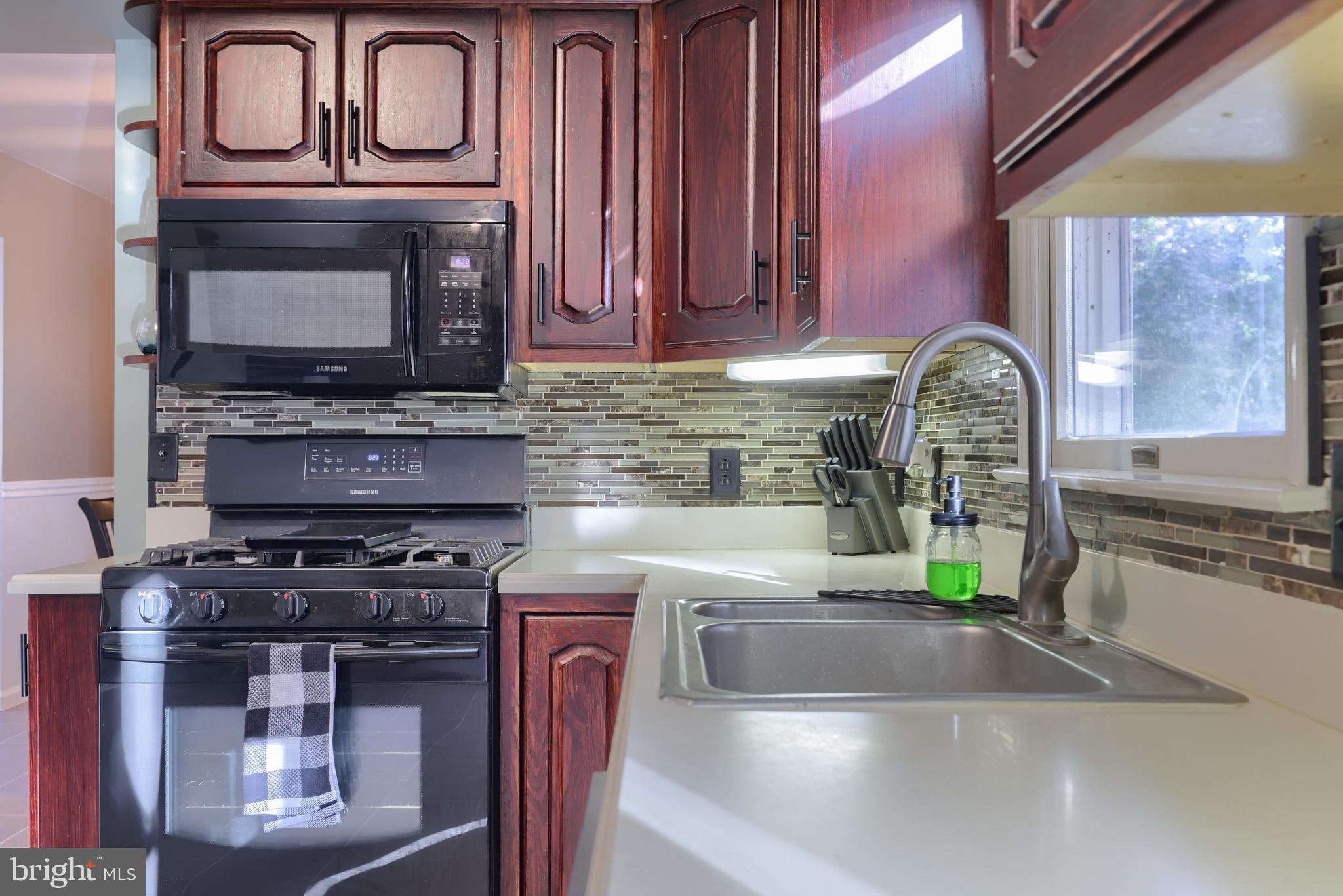 1022 Boeshore Circle Reading, PA 19605 - Photo 17 of 39 a kitchen with stainless steel appliances granite countertop a stove a microwave and a sink