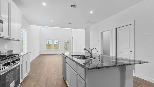 a kitchen with granite countertop a sink and cabinets