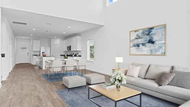 a living room with furniture and a view of kitchen