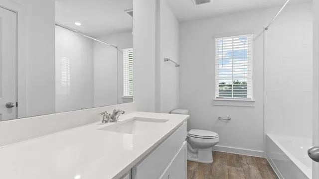 a bathroom with a granite countertop sink a toilet and a large mirror