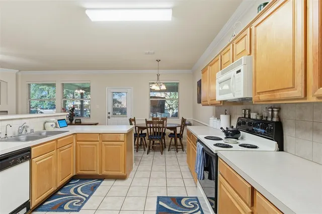a kitchen with a sink a stove and chairs
