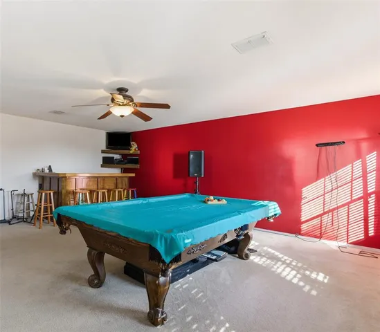 a room with pool table and windows