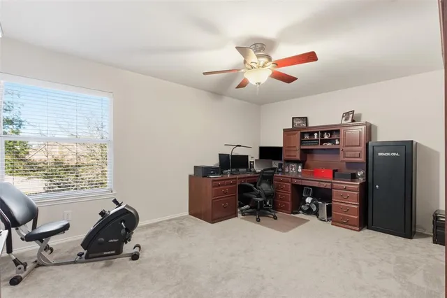 a view of a workspace with furniture and a window