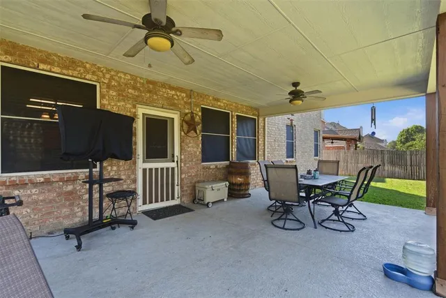 a view of a patio with table and chairs with wooden floor and fence