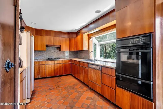 a kitchen with granite countertop a sink and a stove
