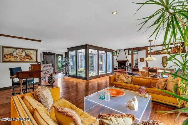 a living room with furniture a rug and a floor to ceiling window